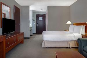 une chambre d'hôtel avec un lit et une télévision à écran plat dans l'établissement Days Inn by Wyndham Whitecourt, à Whitecourt