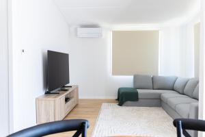 a living room with a couch and a flat screen tv at 40 On North. in Wondoan
