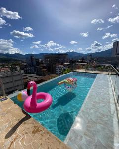 una piscina con un cisne rosa y una pelota en Apartahotel Medellin, en Medellín