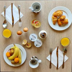 - une table avec des assiettes d'aliments et d'ustensiles pour le petit-déjeuner dans l'établissement Timberlodge, à Oz