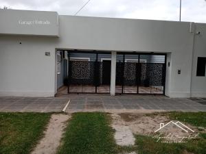 an entrance to a white building with a gate at Casa temporaria Banda II in La Banda