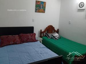a bedroom with two beds with green sheets at Casa temporaria Banda II in La Banda