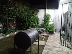 a black barrel sitting in a garden with plants at Casa temporaria Banda II in La Banda