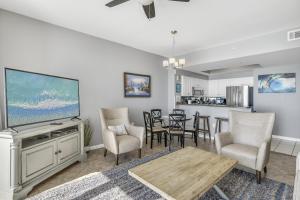 a living room with a tv and a table and chairs at Majestic Sun Resort by Tufan in Destin