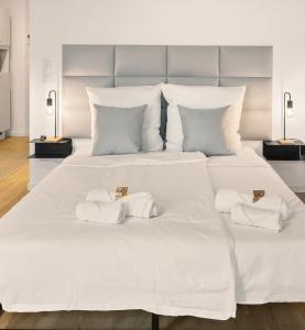 ein großes weißes Bett mit zwei Handtüchern darauf in der Unterkunft Modernes Apartment am Gleispark in Oldenburg