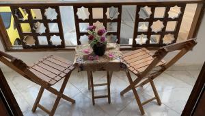 een tafel met een vaas met bloemen en twee stoelen bij شقة فندقية علويه بجوار البحر in Sharm El Sheikh