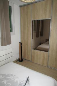 una camera da letto con un grande mobile in legno con specchio di Appartement T2 neuf Bages centre a Bages