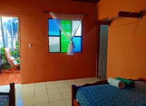 a bedroom with a bed and a window at Rustic House Hostel in Moyogalpa