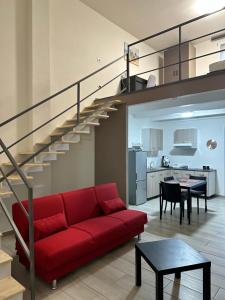 a living room with a red couch and a staircase at Terra Mia Residence in Mugnano di Napoli