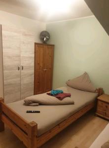um quarto com uma cama de madeira e um armário em APARTMENT / WOHNUNG IN HAIBACH em Haibach
