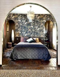 - une chambre avec un lit et un mur orné d'un lustre dans l'établissement Studio indépendant comme une suite d’hôtel, à Villers-Cotterêts