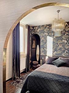 - une chambre avec un grand lit et un lustre dans l'établissement Studio indépendant comme une suite d’hôtel, à Villers-Cotterêts