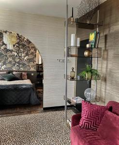 - un salon avec un lit et un canapé violet dans l'établissement Studio indépendant comme une suite d’hôtel, à Villers-Cotterêts