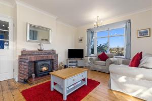 a living room with a fireplace and a couch at Four Oaks - Sea and Harbour Views in Saundersfoot