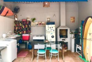 La cuisine est équipée d'une table, de chaises et d'un réfrigérateur. dans l'établissement SURFuncional Guest House, à Bertioga