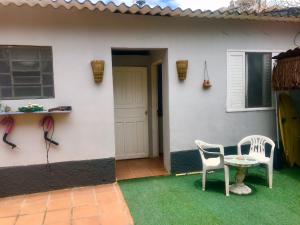 een patio met 2 stoelen en een tafel voor een huis bij SURFuncional Guest House in Bertioga
