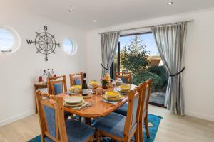 a dining room with a wooden table and chairs at Four Oaks - Sea and Harbour Views in Saundersfoot