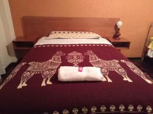 una cama con dos jirafas estampadas en la manta en La Quiteñita Papallacta, en Papallacta