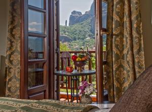 a room with a balcony with a table with fruit on it at Hotel Doupiani House in Kalabaka
