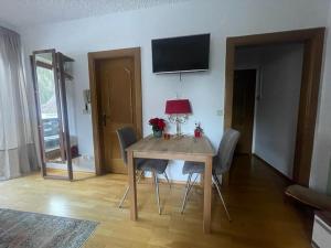 a dining room with a table with chairs and a television at Haus Karin Mallnitz in Mallnitz