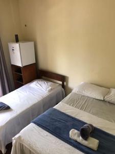 2 Betten in einem Zimmer mit einem Handtuch auf dem Bett in der Unterkunft Pousada Tupaiú in Alter do Chao