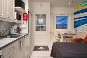 una pequeña cocina con cama y lavabo en Pikkuriikkinen yksiö kaikilla herkuilla Levin keskustassa, en Levi