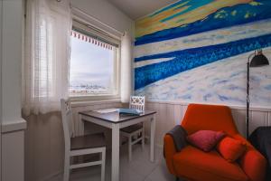 Habitación con escritorio, silla y pintura en Pikkuriikkinen yksiö kaikilla herkuilla Levin keskustassa, en Levi