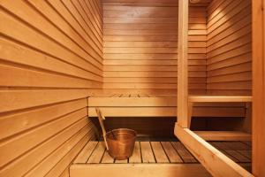 una pequeña sauna de madera con un cubo dentro en Pikkuriikkinen yksiö kaikilla herkuilla Levin keskustassa, en Levi 1 foto más