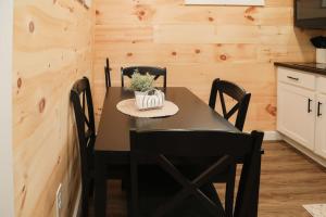 a dining room with a black table and chairs at Hartman Center Campground in Milroy