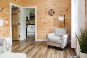 a living room with a chair and a clock on a wall at Hartman Center Campground in Milroy