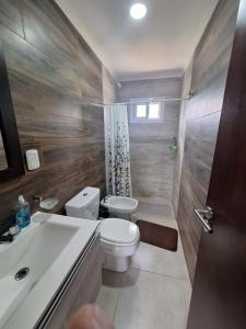 ein Badezimmer mit einem WC, einem Waschbecken und einer Badewanne in der Unterkunft Alberdi 1218 in Colón
