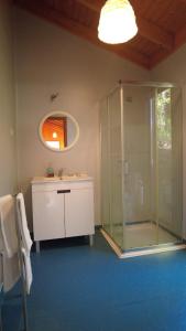 a bathroom with a glass shower and a sink at Sobre Aguas Camping in Bragança