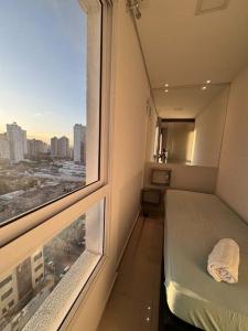 een kleine kamer met een bed en een raam bij Studio 520 - Loft no DNA SmartStyle in Goiânia