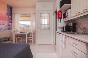 a small kitchen with a sink and a table at Cozy studio with sauna in the middle of Levi in Levi