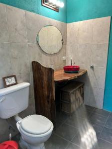 a bathroom with a toilet and a sink and a mirror at Departamento serrano in Nono