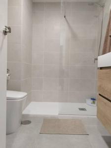 a white bathroom with a shower and a toilet at Estudio Playa Jardín in Puerto de la Cruz