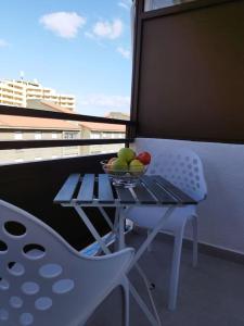 a table and a chair with a bowl of fruit on a balcony at Estudio Playa Jardín in Puerto de la Cruz