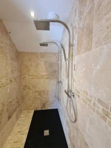 a bathroom with a shower with a shower head at Norville in Horam