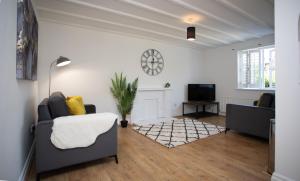 a living room with a couch and a tv at Apartment in the heart of Old Town Beaconsfield in Buckinghamshire