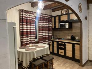 eine Küche mit einem Tisch mit Stühlen und eine Küche mit einer Theke in der Unterkunft ЕКО-котедж in Werchowyna