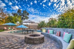 un patio con braciere, tavoli e ombrelloni di Resort Style Desert Oasis, Pool, Golf, Billiards & Ping Pong a Gilbert