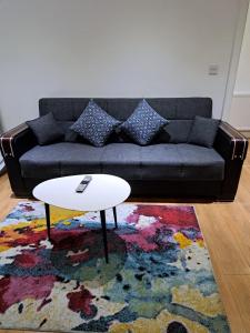 a living room with a couch and a coffee table at Simply Relax, Eastham London in London