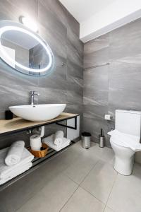 een badkamer met een wastafel, een toilet en een spiegel bij Pagani Green - Luxury Studio A1 in Kalamata