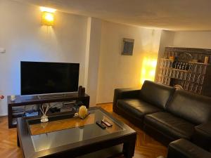 Una sala de estar con un sofá de cuero y una mesa de café. en Dorobanți Loft, en Bucarest