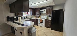 eine Küche mit braunen Schränken und einem schwarzen Kühlschrank in der Unterkunft Horse Ranch Home 5 room 2.5 bath in Las Vegas