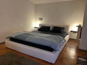 Un dormitorio con una gran cama blanca con dos almohadas. en Dorobanți Loft, en Bucarest