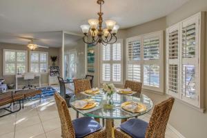 a dining room with a glass table and chairs at Myrtle Beach Home with Saltwater Pool, Walk to Beach in Myrtle Beach