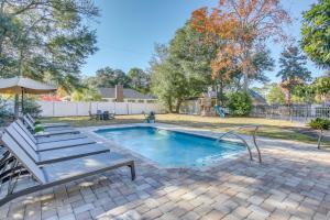 a swimming pool with a bench and an umbrella at Myrtle Beach Home with Saltwater Pool, Walk to Beach in Myrtle Beach