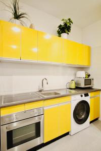 una cucina con armadi gialli e lavastoviglie di Luxury Apartment in Praterstern area a Vienna