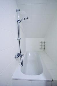 a white bath tub with a shower in a bathroom at Luxury Apartment in Praterstern area in Vienna